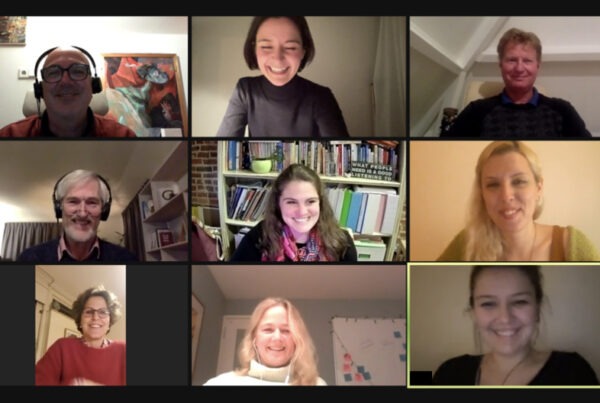9 people in a zoom call, laughing and smiling